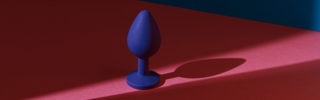 blue buttplug sex toy colorful background photo anal toy adult with contrast shadows