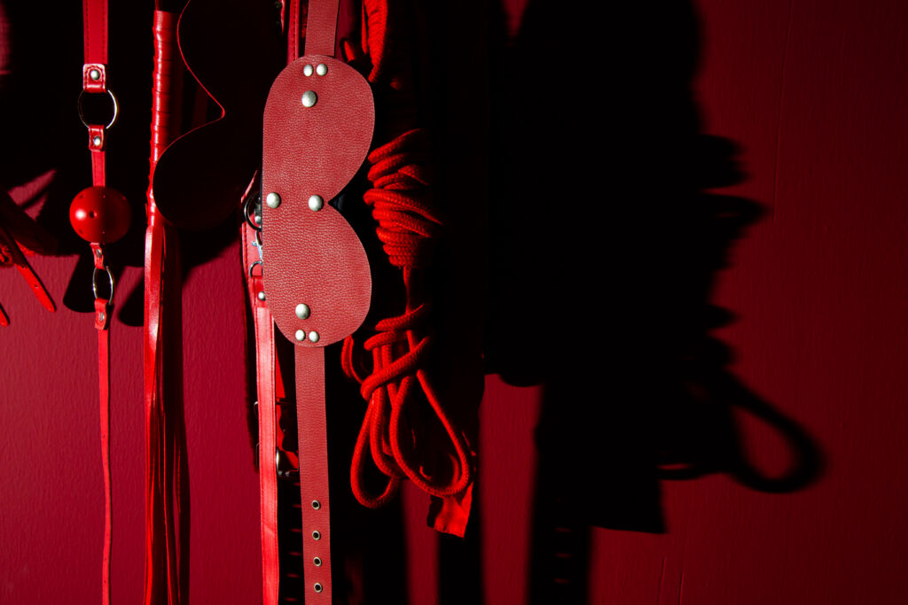 close up sex toys hanging against wall