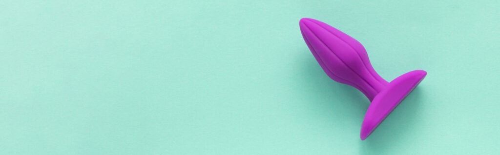 purple anal plug green background sex toys copy space text banner