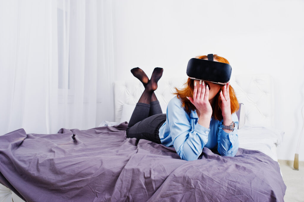 red haired girl bed with vr glasses studio room