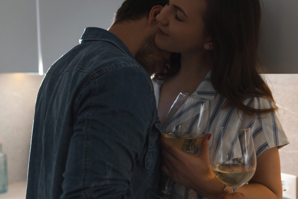 woman holding wineglass embracing with partner